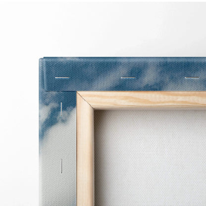 Corner close-up of canvas wall art stretched over wooden frame with blue and white painted edges.