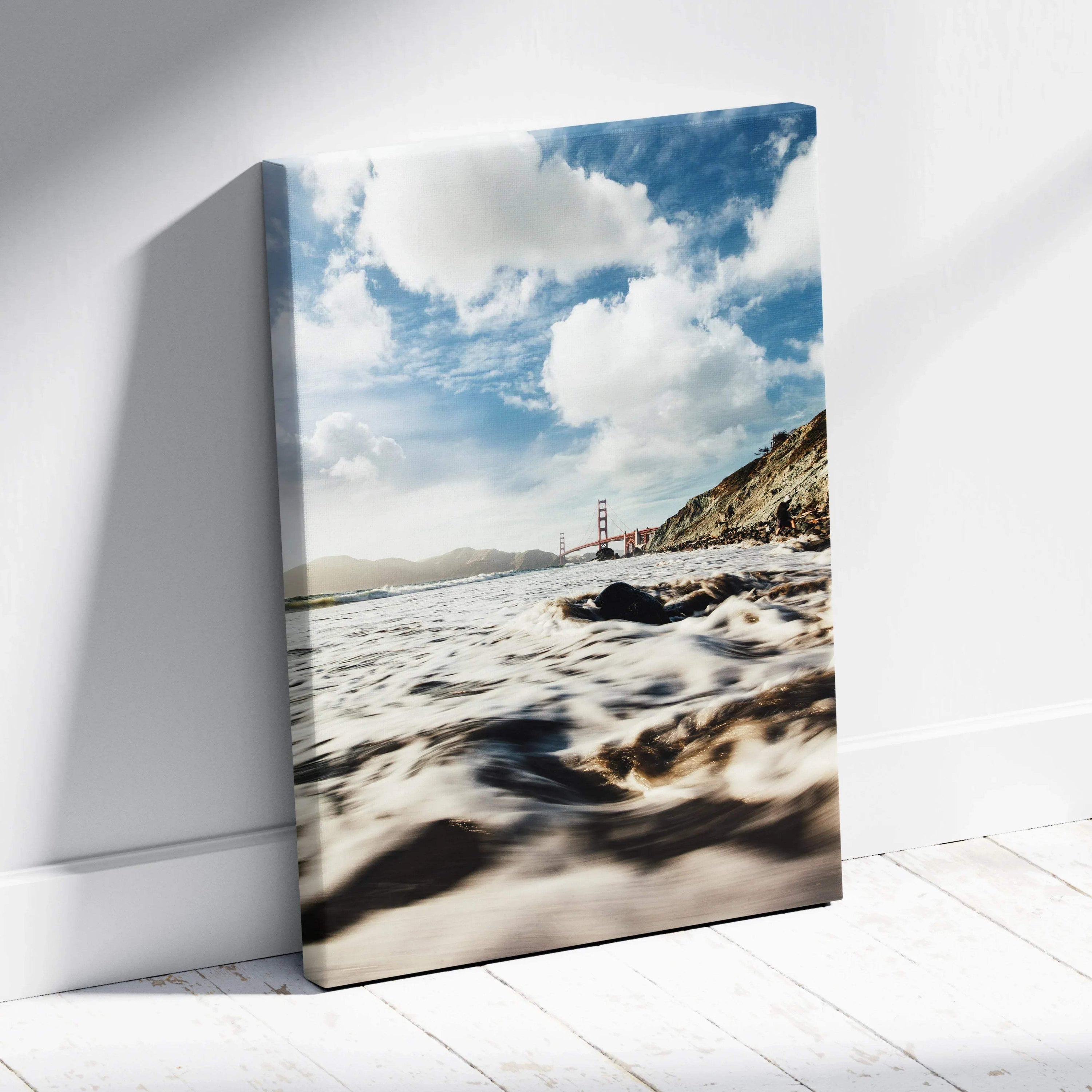 Serene beach with waves and Golden Gate Bridge under blue sky on vertical canvas wall art.