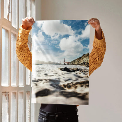 Vertical poster of Golden Gate Bridge with ocean waves and rocky shoreline, bright sky wall art.