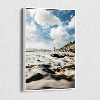 Canvas wall art depicting a serene beach scene with waves and the Golden Gate Bridge under a cloudy sky.