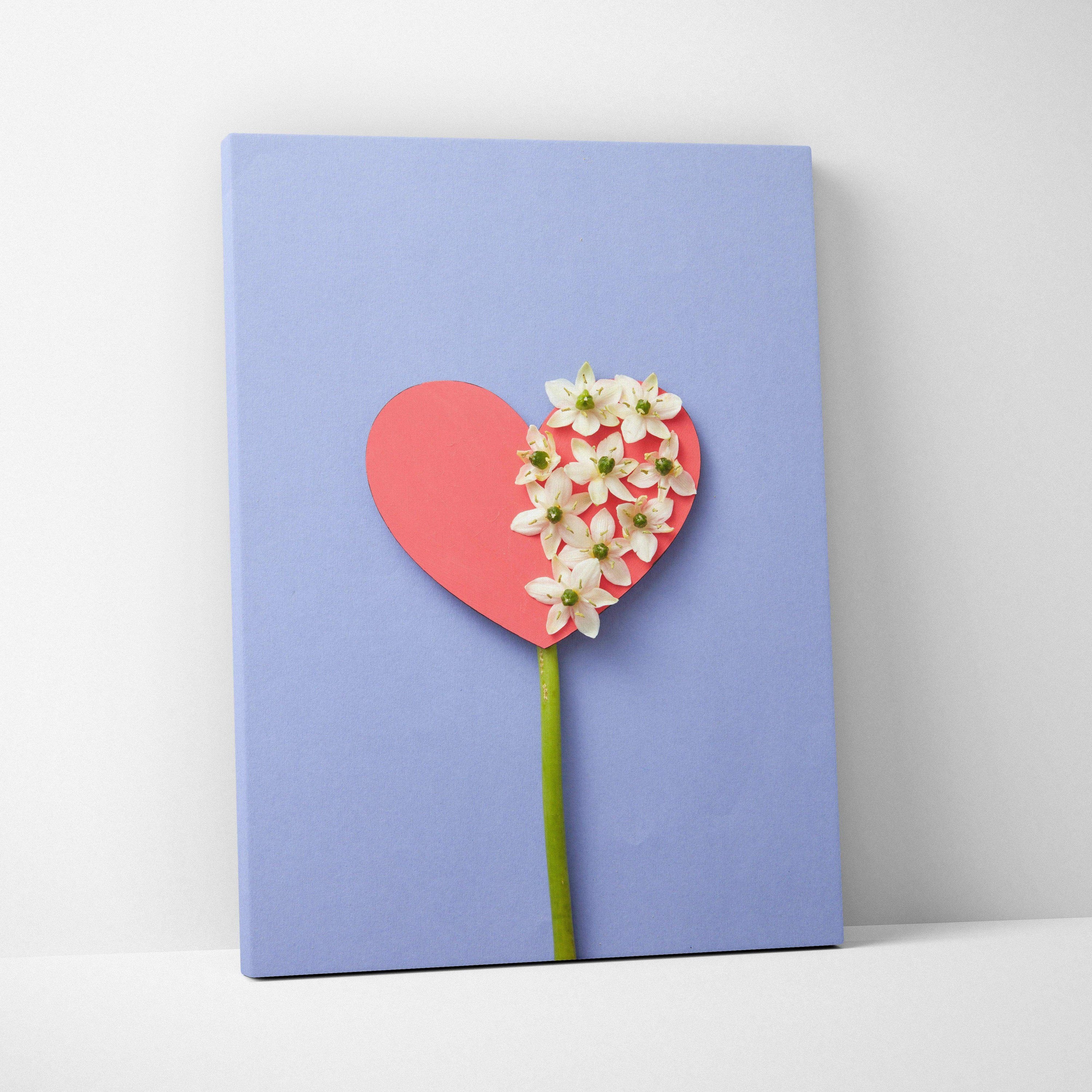 Pastel blue heart canvas wall art with white flowers and green stem