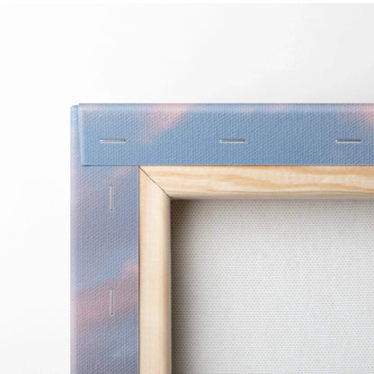 Close-up of wooden frame and stretched canvas edge showing sunset hues, wall art detail.