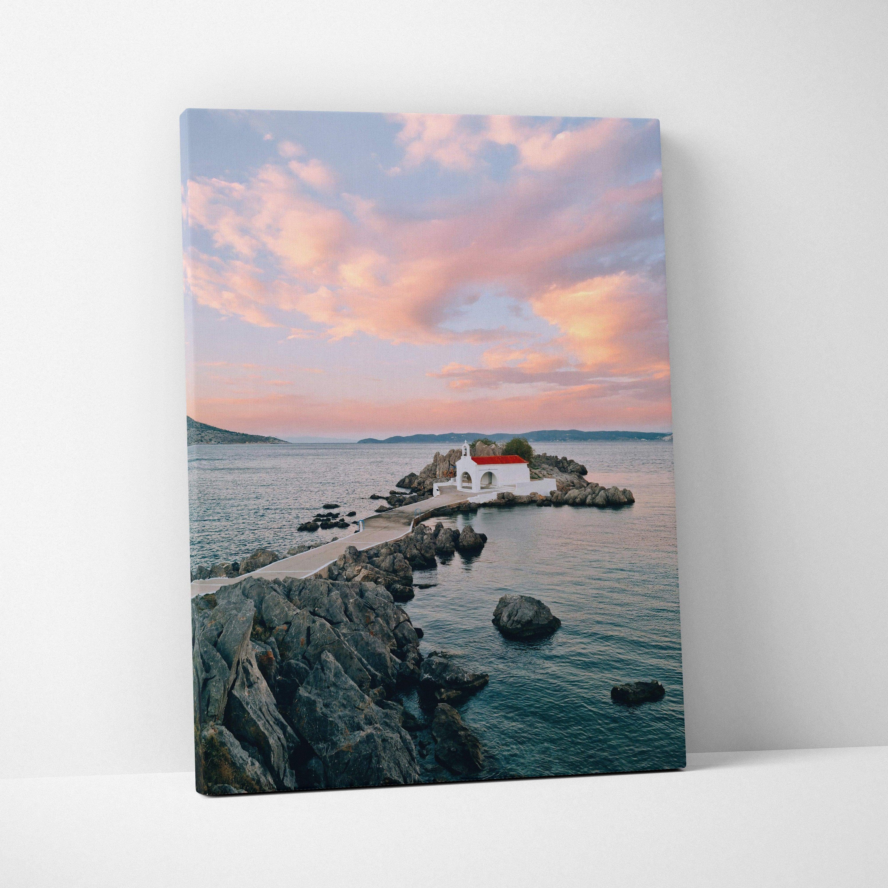 Canvas wall art of a serene beach scene with small white buildings and a pink sunset sky.
