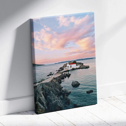 Sunset beach scene with rocky pier and white buildings on canvas wall art.