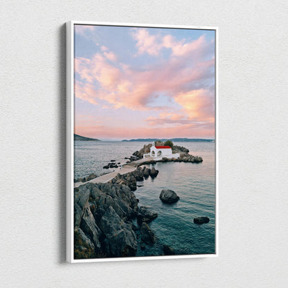 Canvas wall art featuring serene sunset over rocky coastline with small white building and calm water.