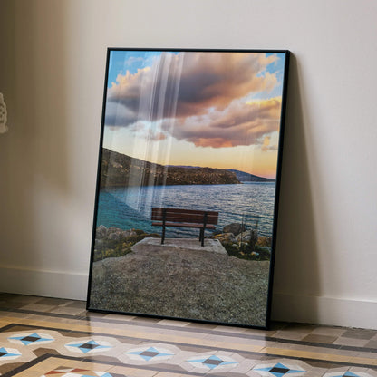 Vertical wall art poster featuring a vibrant sunset over a lakeside bench and rocky shore.