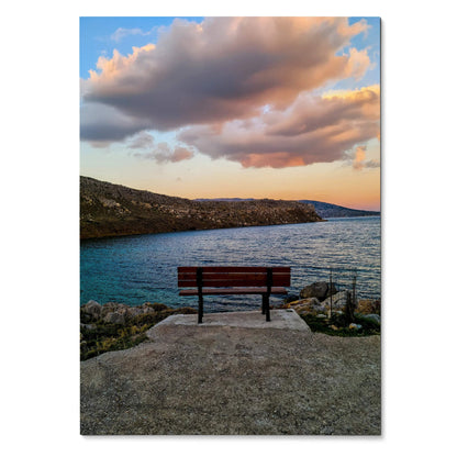 Vibrant sunset landscape poster featuring a bench overlooking a rocky coastline and calm water wall art.