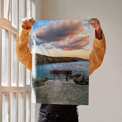 Sunset landscape art poster with vibrant sky, calm water, and empty bench by the shore.