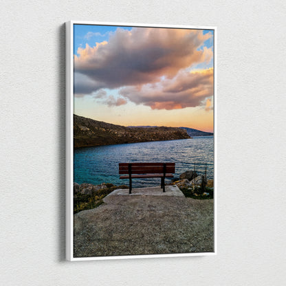 Sunset landscape canvas wall art with a bench overlooking ocean and rocky coast under vibrant clouds.
