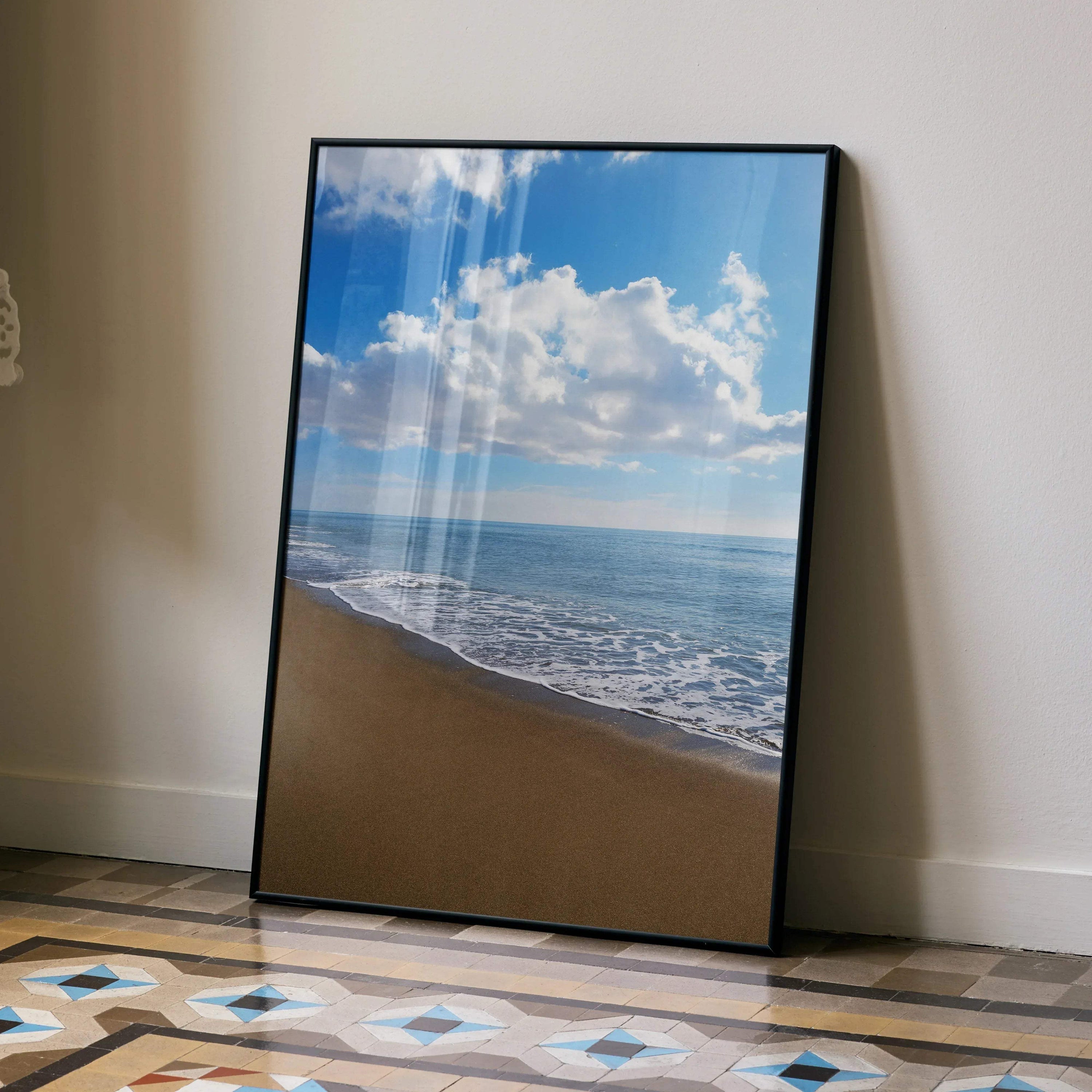 Vibrant ocean waves beach scene poster with blue sky clouds wall art in black frame.