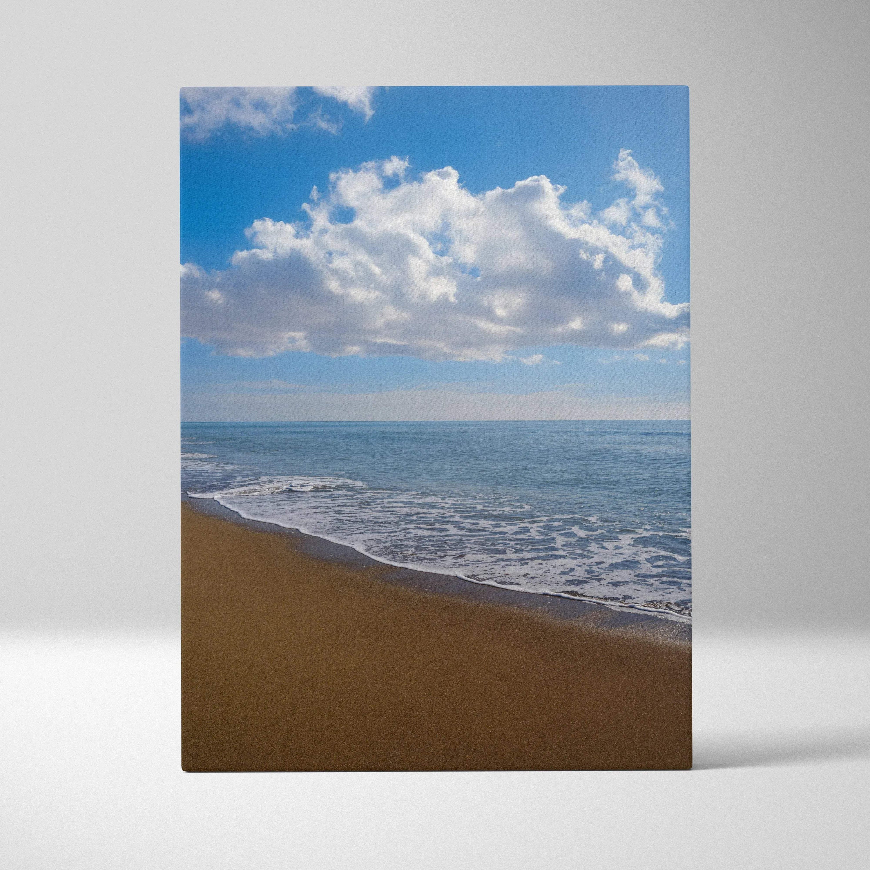 Serene beach landscape canvas wall art with sandy shore, gentle waves, and bright blue sky with clouds.