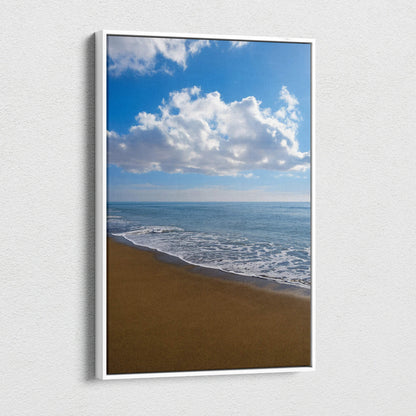 Vertical canvas wall art depicting a serene beach with gentle waves and blue sky with clouds.