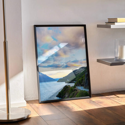 Vertical poster wall art featuring vibrant mountains and a colorful sunset over water.