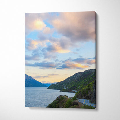 Vertical canvas wall art featuring a serene mountain landscape at sunset with soft clouds and a calm lake.