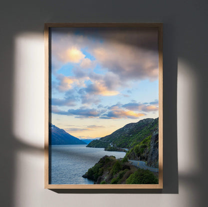 Vertical wall art poster featuring vibrant mountains and sunset over a lake with dramatic clouds.