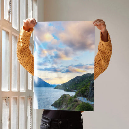Vertical wall art poster featuring vibrant mountains and a colorful sunset over a scenic coastal road.
