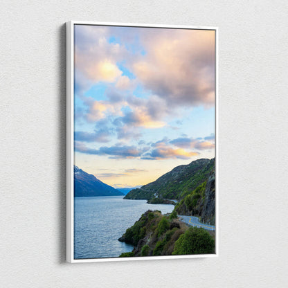 Vertical canvas wall art showcasing a mountain lake at sunset with colorful clouds and green hills.