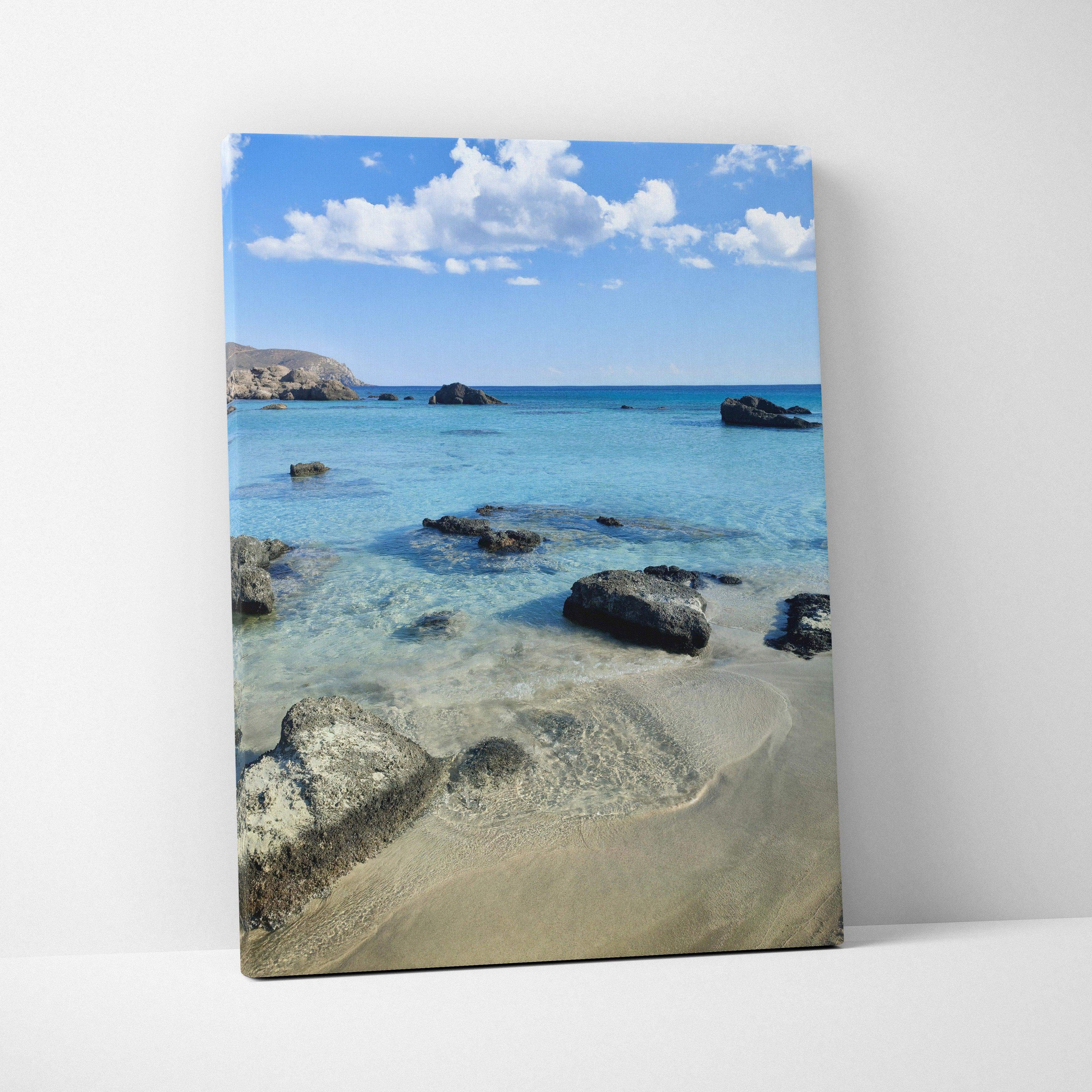 Beach scene with clear blue water and rocks on canvas wall art print.