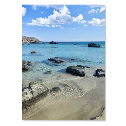 Vertical beach landscape poster featuring clear blue water, sandy shore, and scattered rocks, wall art with vibrant sky and.