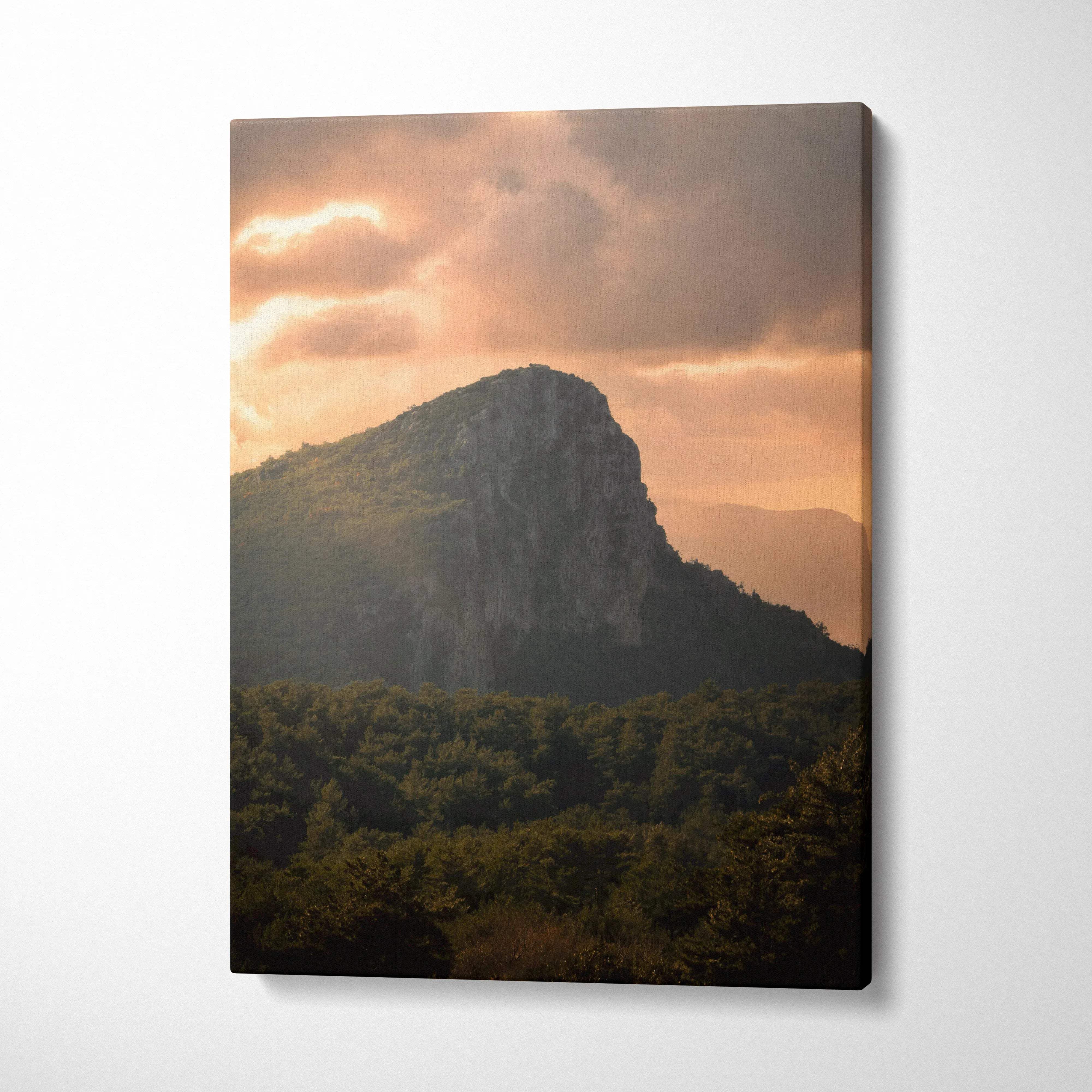 Mountain sunset canvas wall art with dramatic clouds and forested foreground.