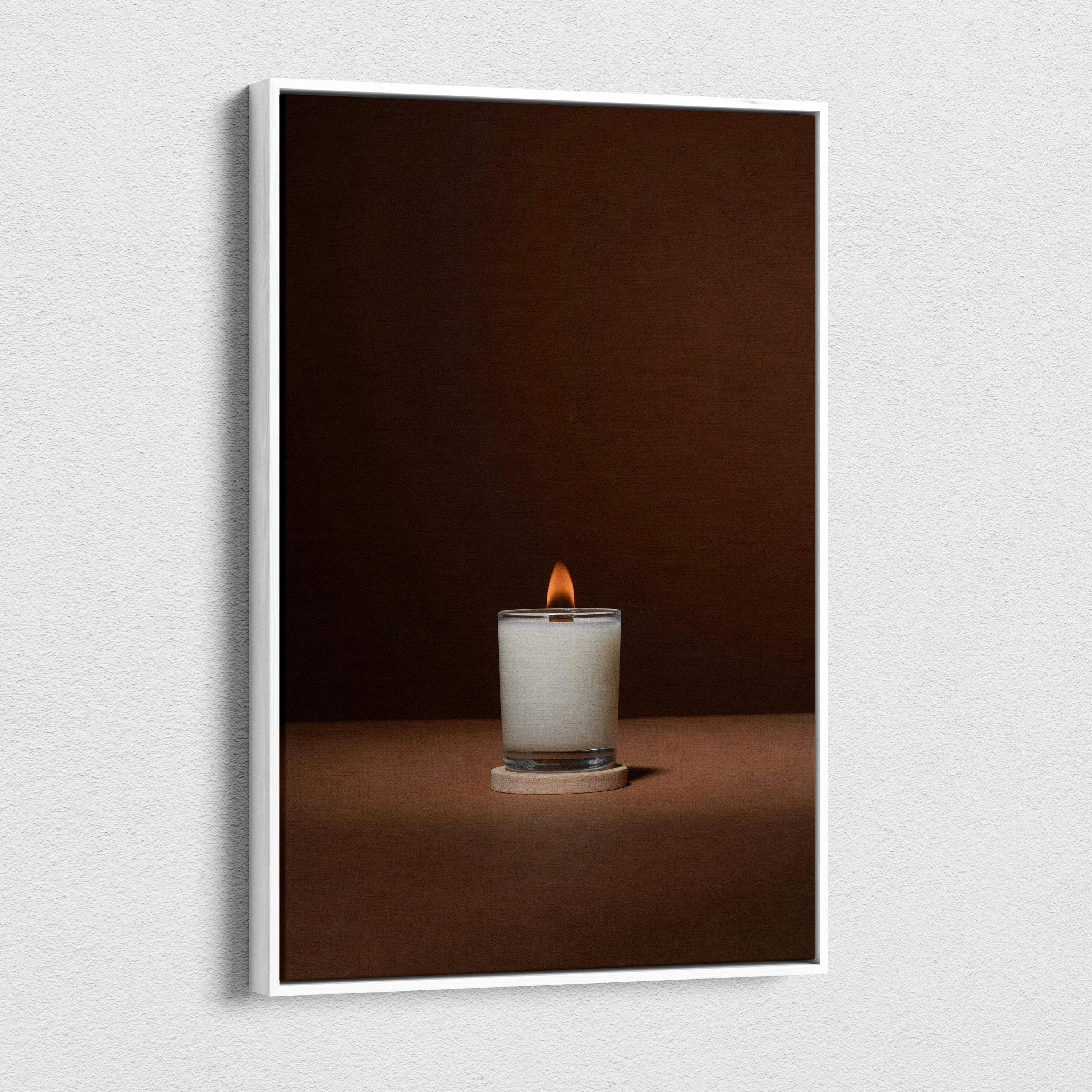 Minimalist white candle in glass jar with warm glow on brown backdrop