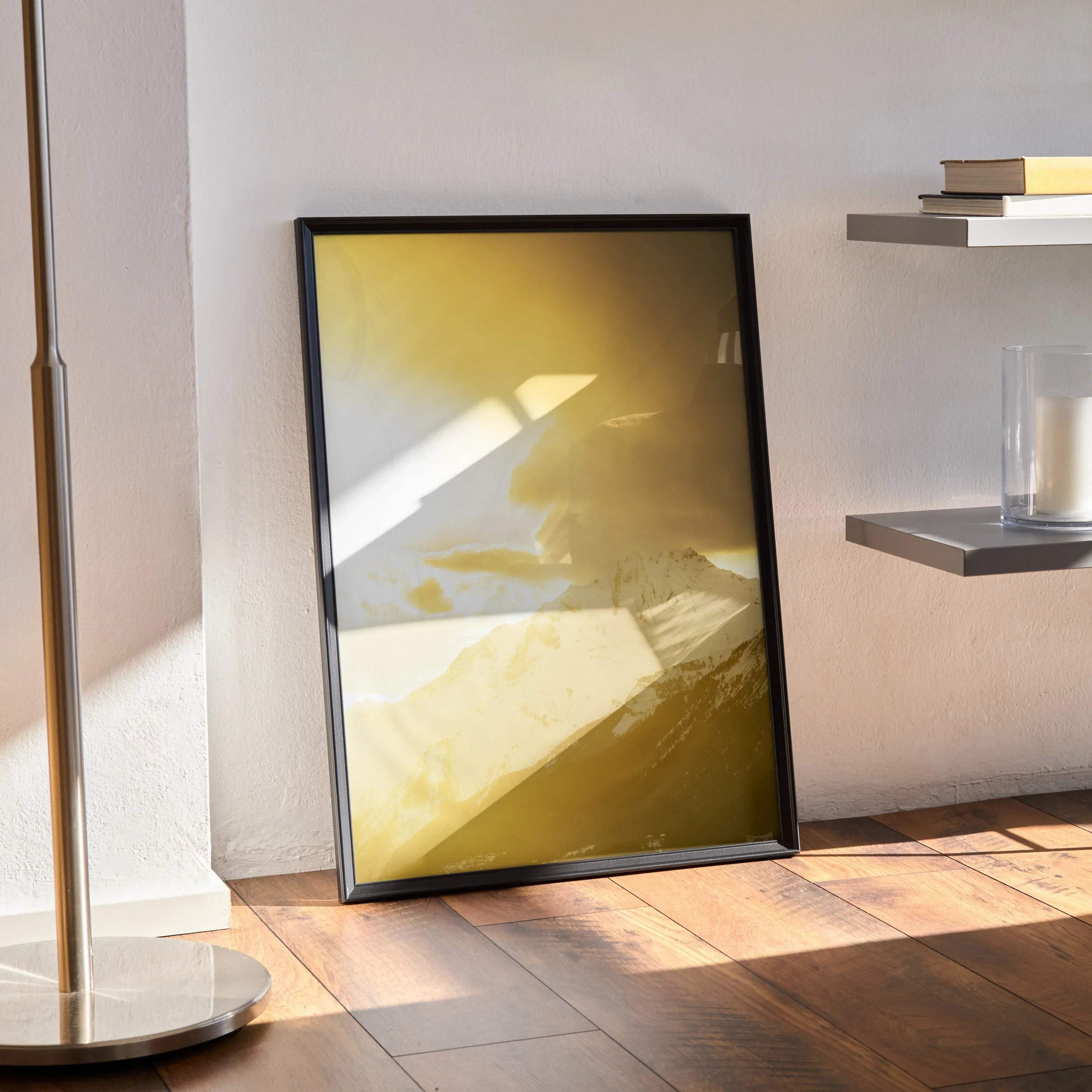 Abstract golden mountain sunset poster with black frame leaning on wall, modern wall art.