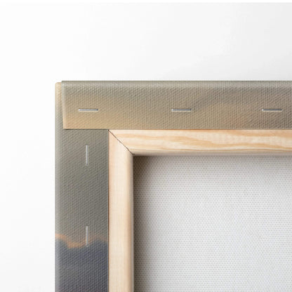 Close-up of wooden frame corner and stretched canvas of vertical wall art with snowy sunset nature print.
