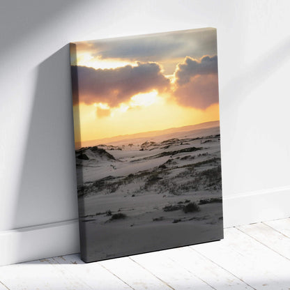 Canvas wall art depicting a snowy landscape at sunset with dramatic clouds and warm light.