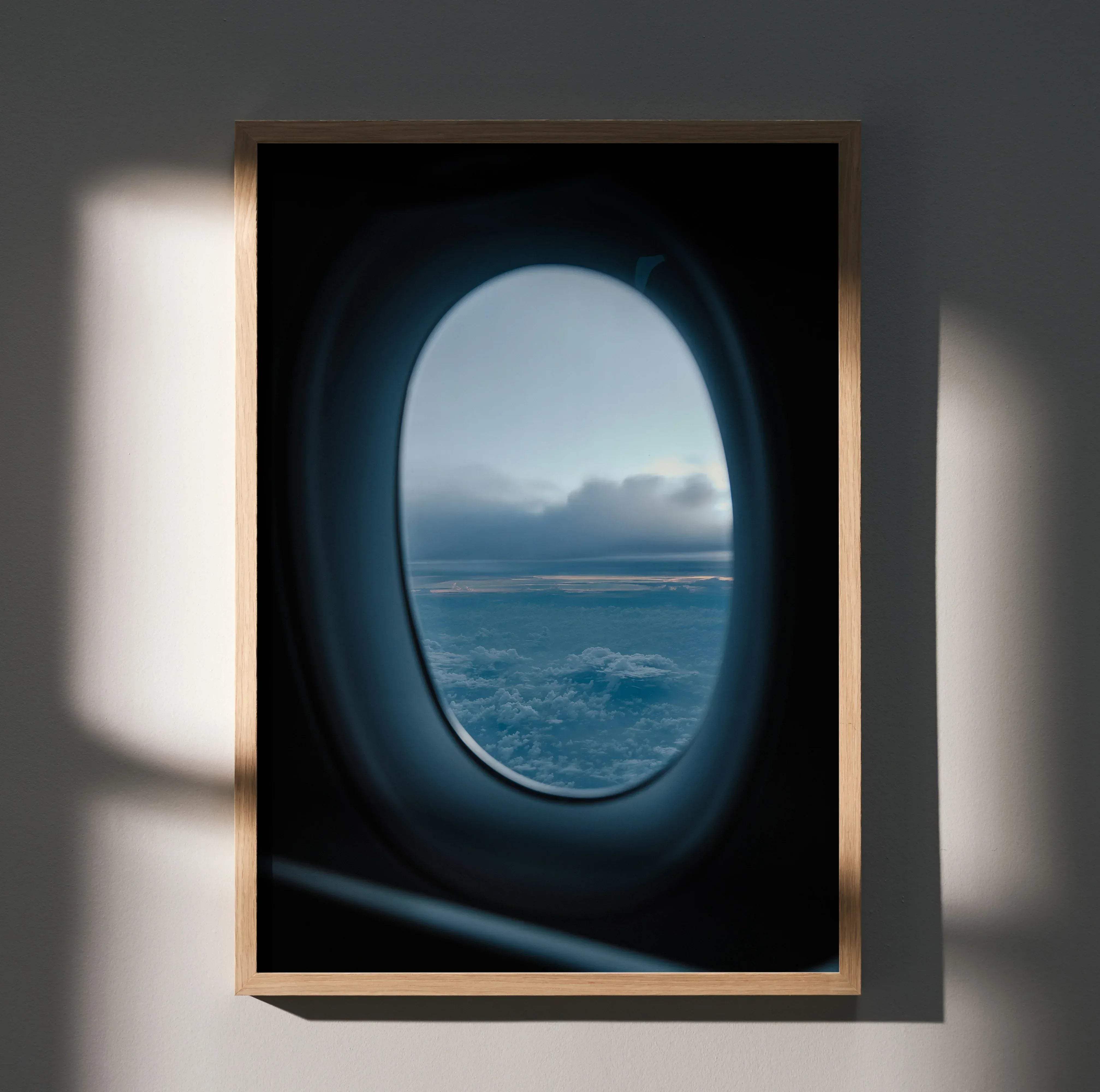 A framed inspiring flight birds wall art poster print featuring a circular airplane window view with clouds and land