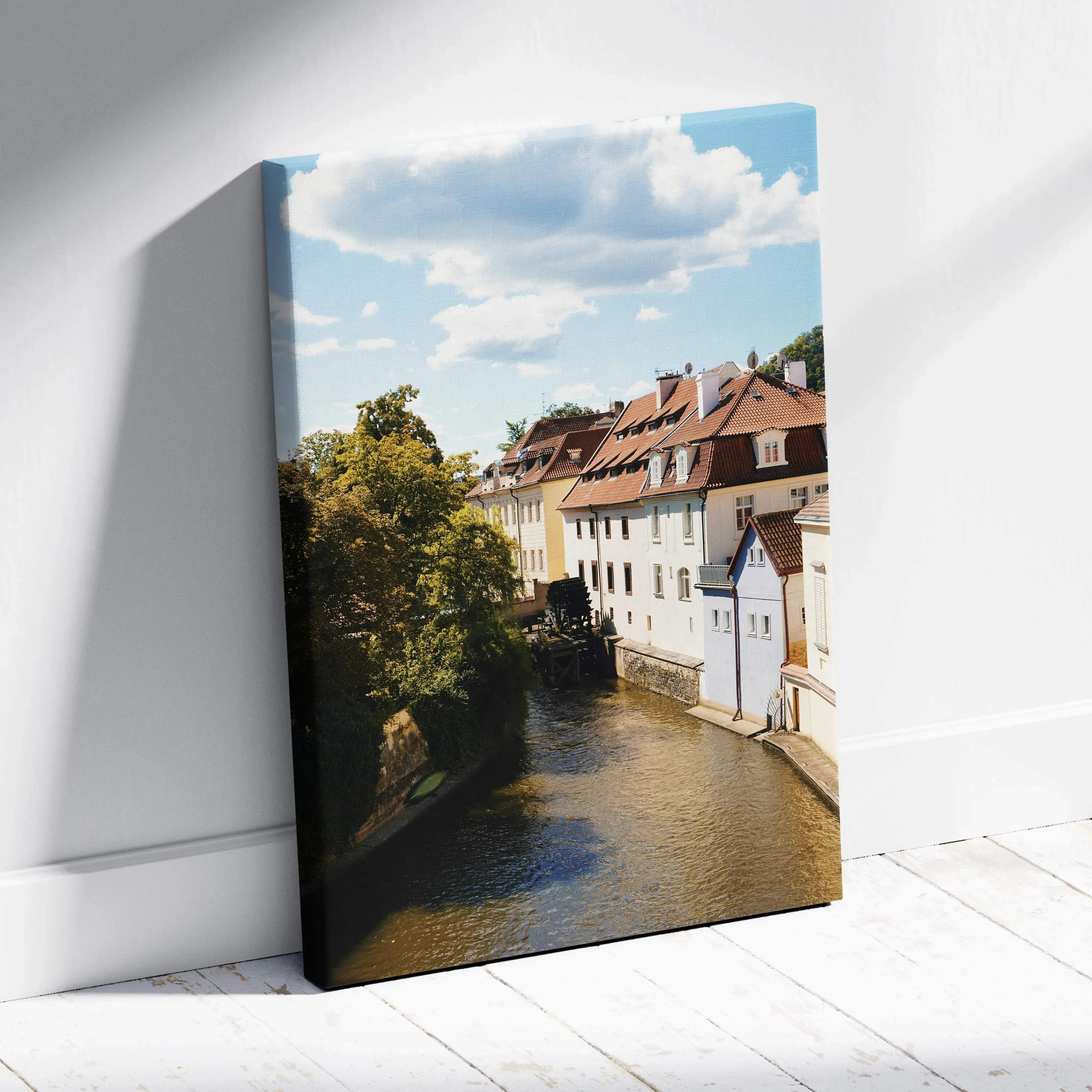 Rectangular canvas print of a classic european cityscape with white buildings red roofs along a river on a sunny day