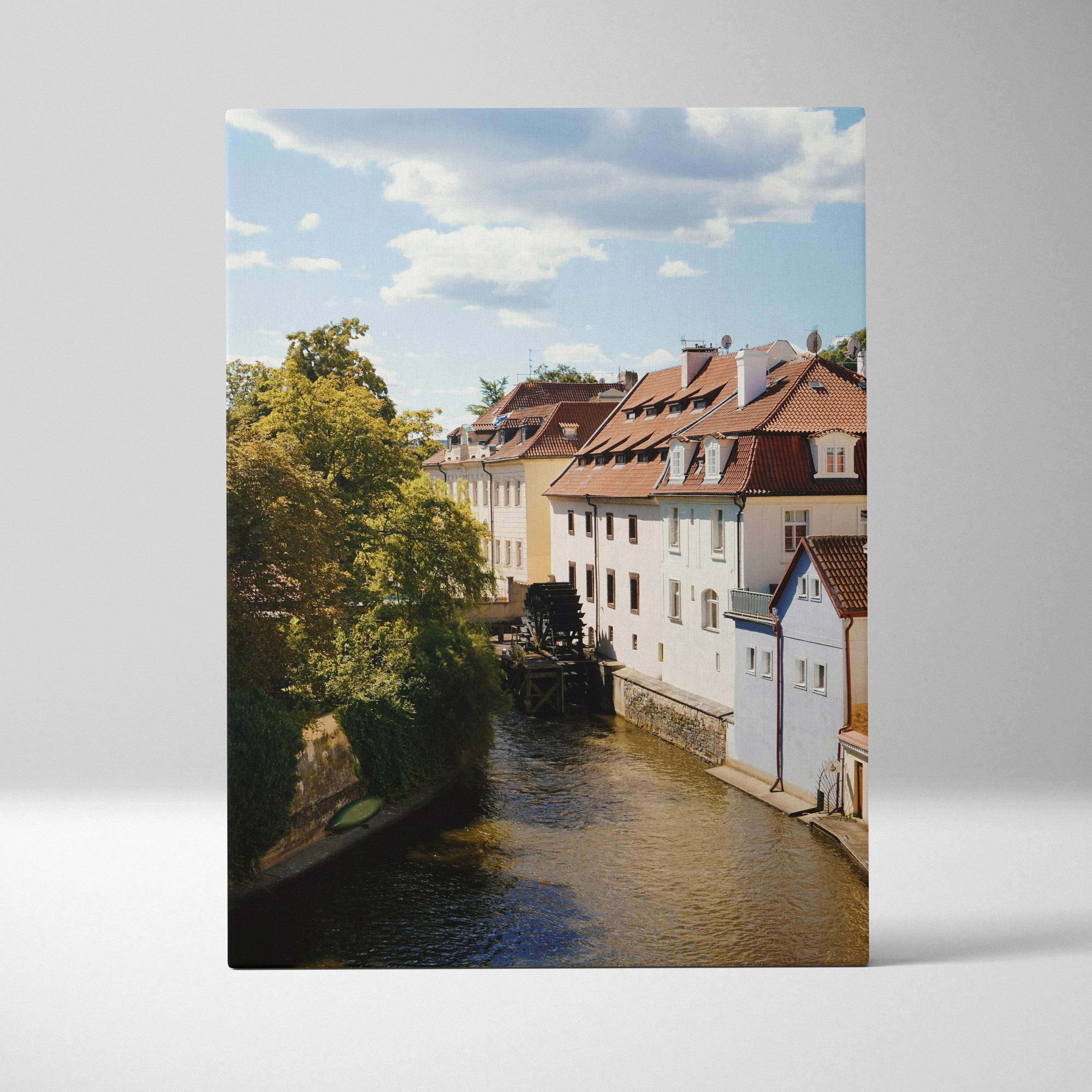 Rectangular canvas print of a classic european cityscape with colorful buildings and lush trees along a riverside canal