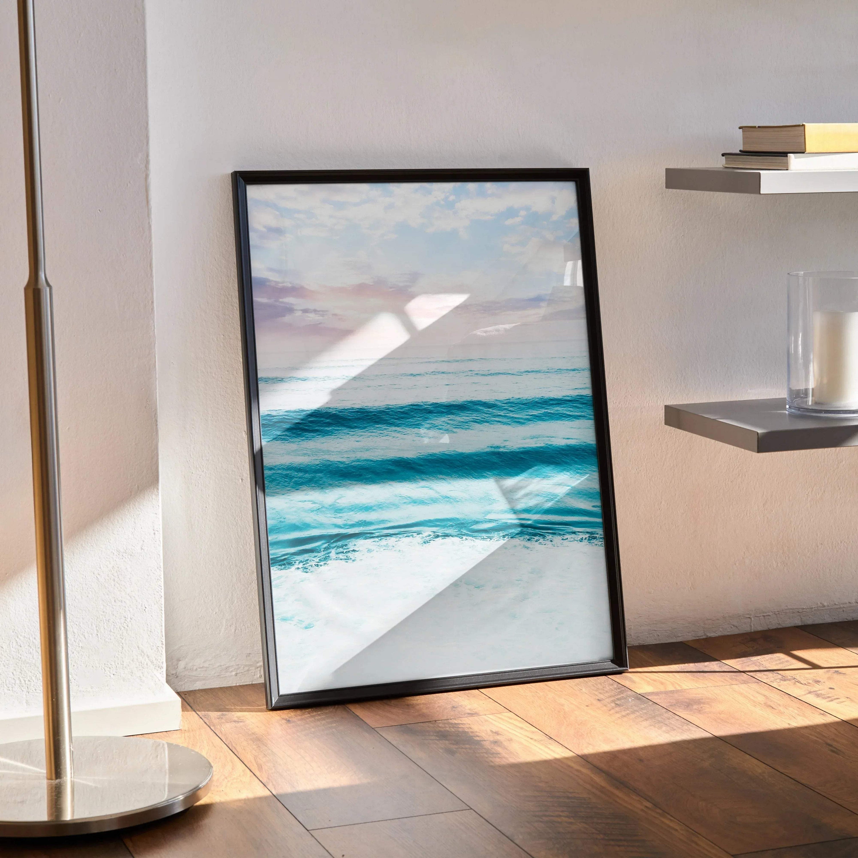 Ocean sunset poster with vibrant blue waves and soft pastel sky in black frame wall art.