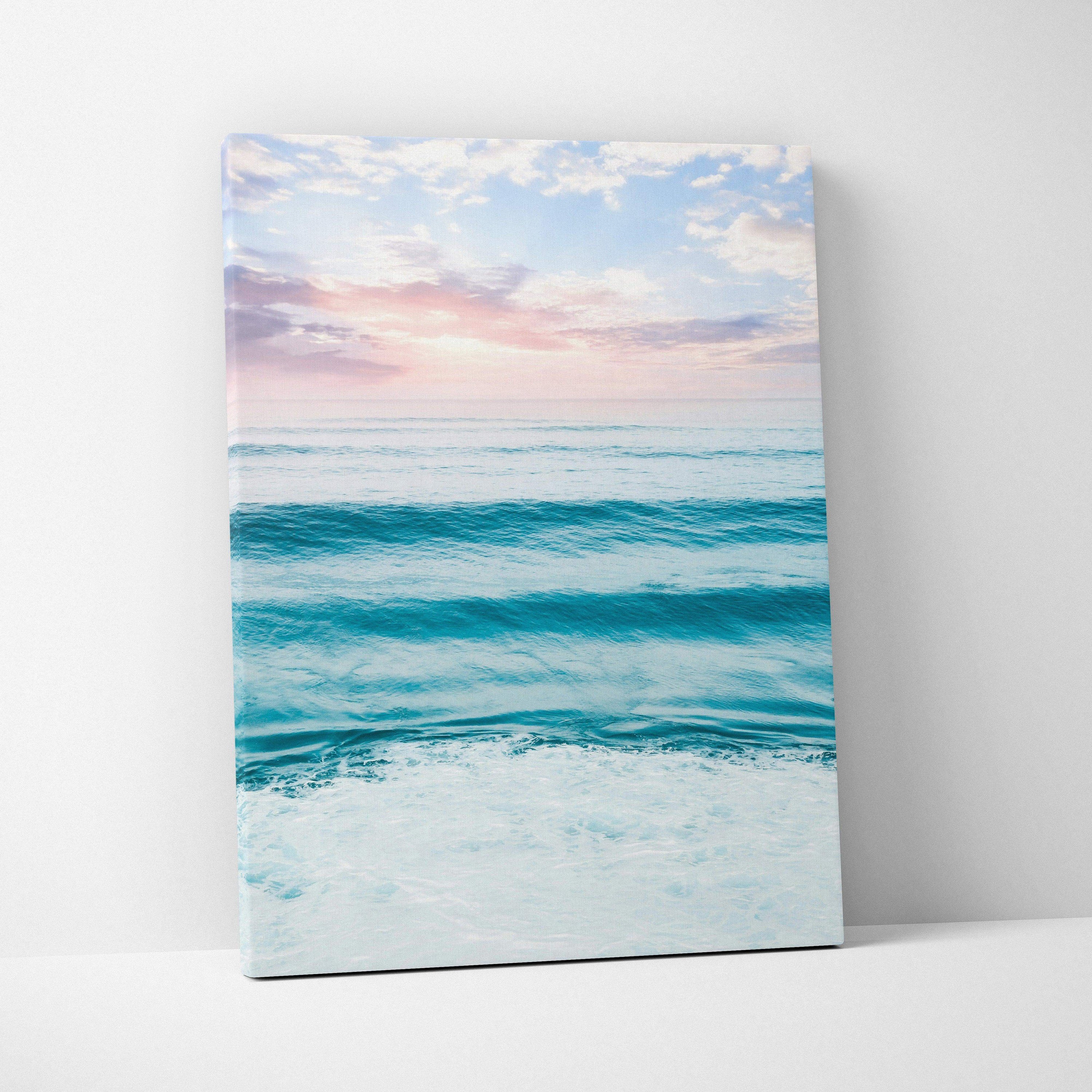 Vertical canvas wall art featuring a serene beach ocean scene with soft pastel sunset colors.