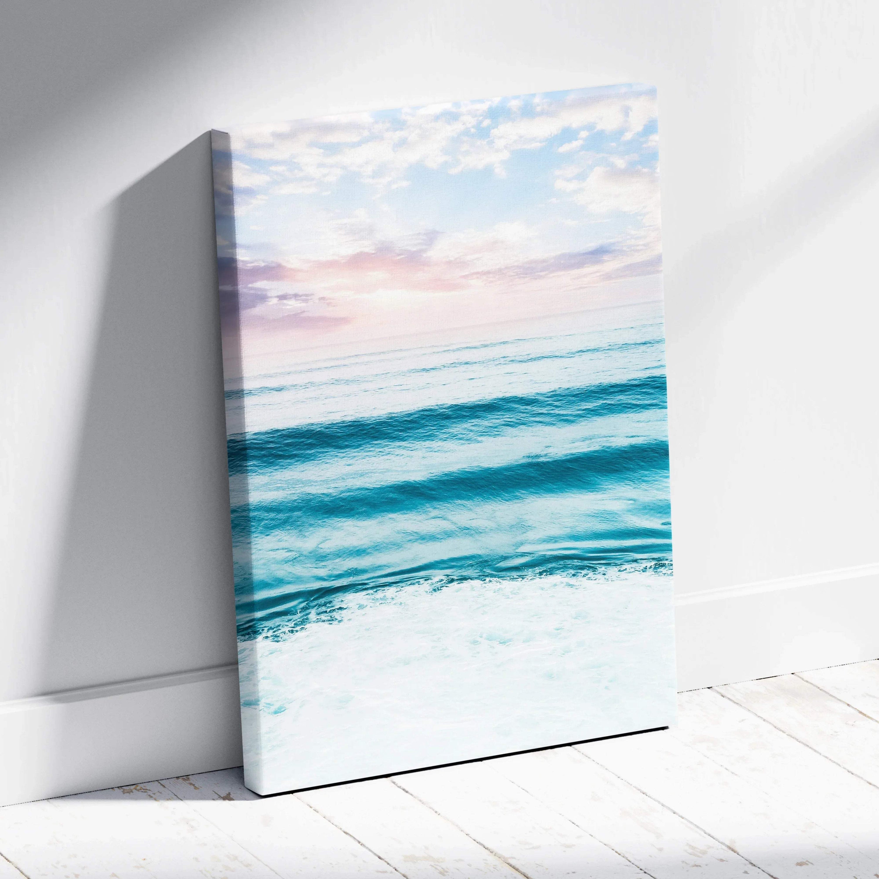 Sunset over calm blue ocean waves on vertical canvas wall art with soft pastel sky.