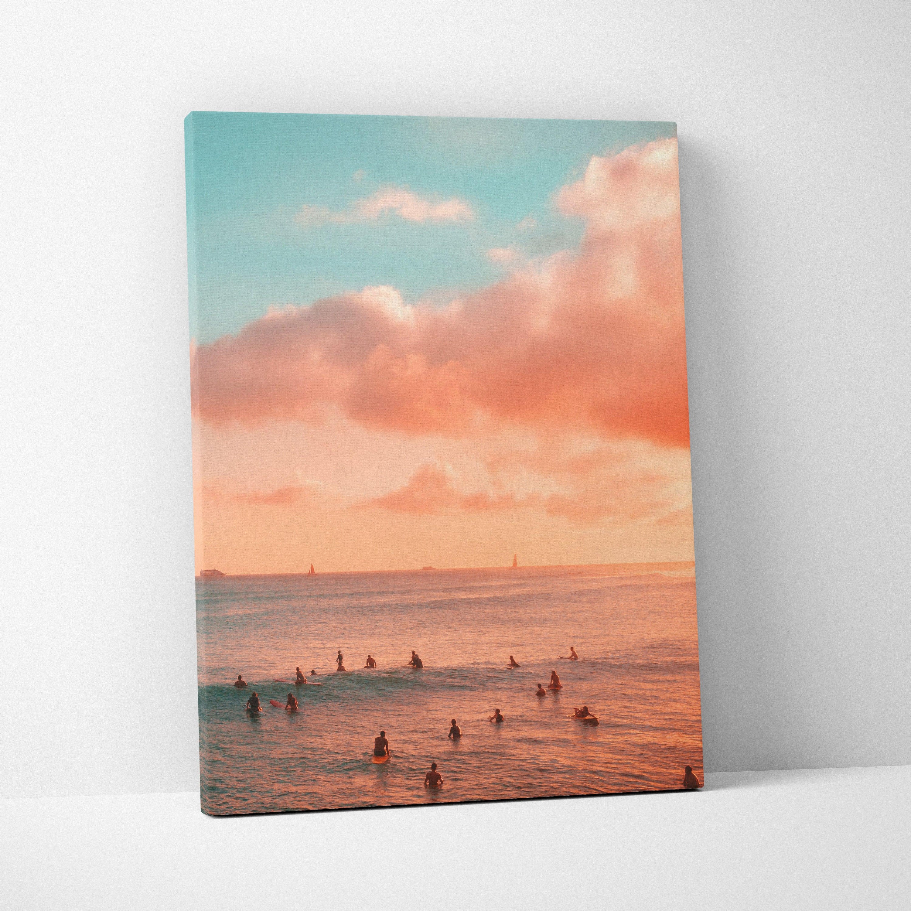 Canvas wall art of a golden sunset over ocean beach with swimmers in calm water and soft clouds.