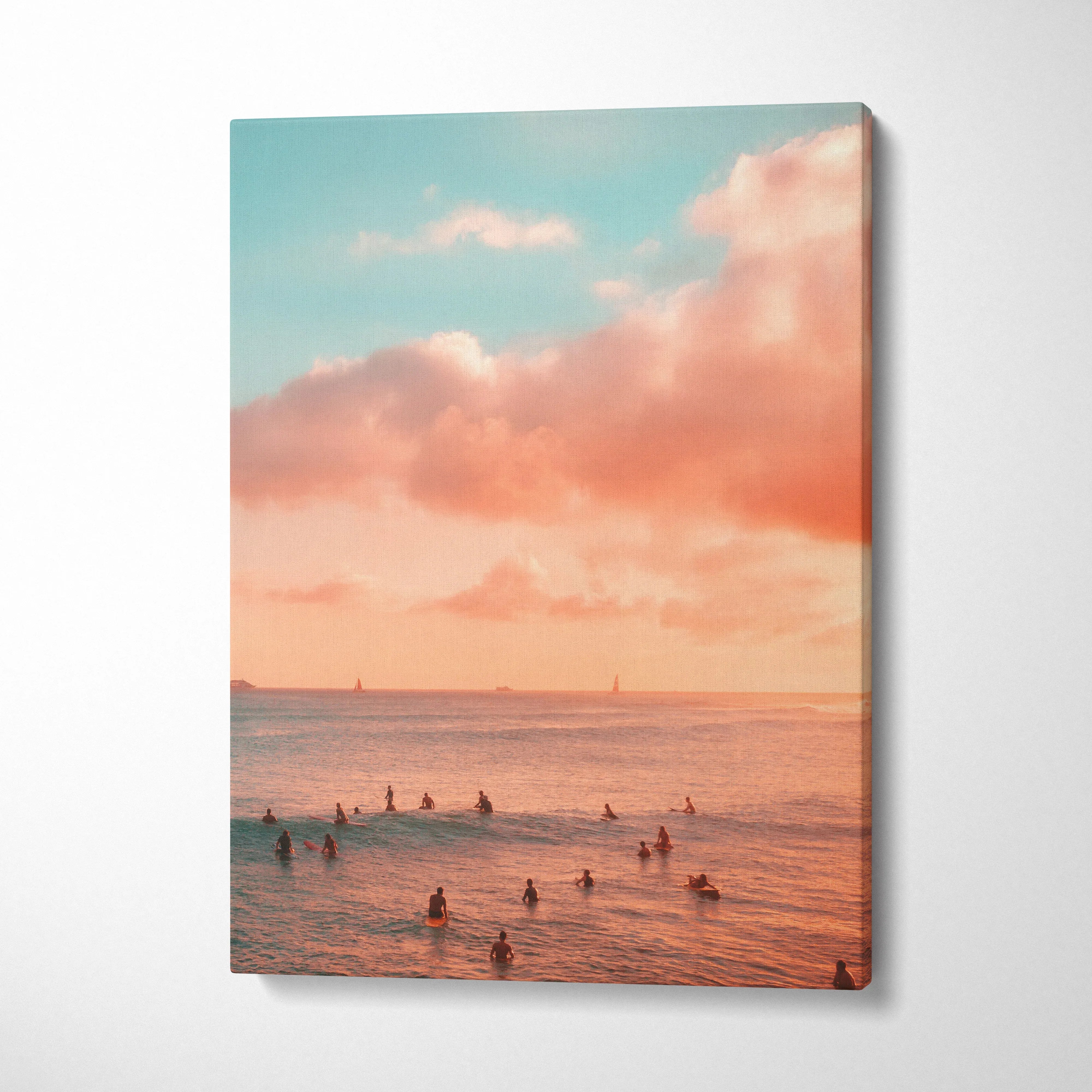 Vertical canvas wall art of surfers in calm ocean waters under a pink and blue sunset sky.