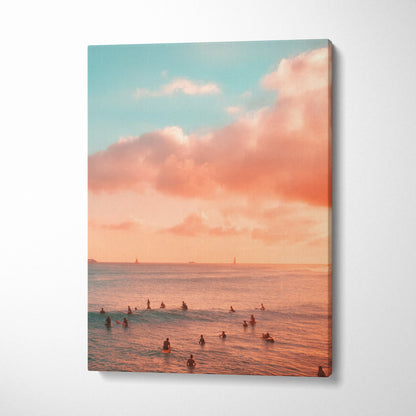 Vertical canvas wall art of surfers in calm ocean waters under a pink and blue sunset sky.