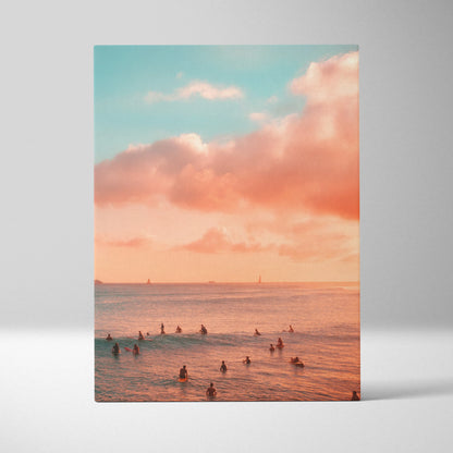Vertical canvas wall art depicting a golden sunset over ocean waves with swimmers in the water and soft pink clouds above.