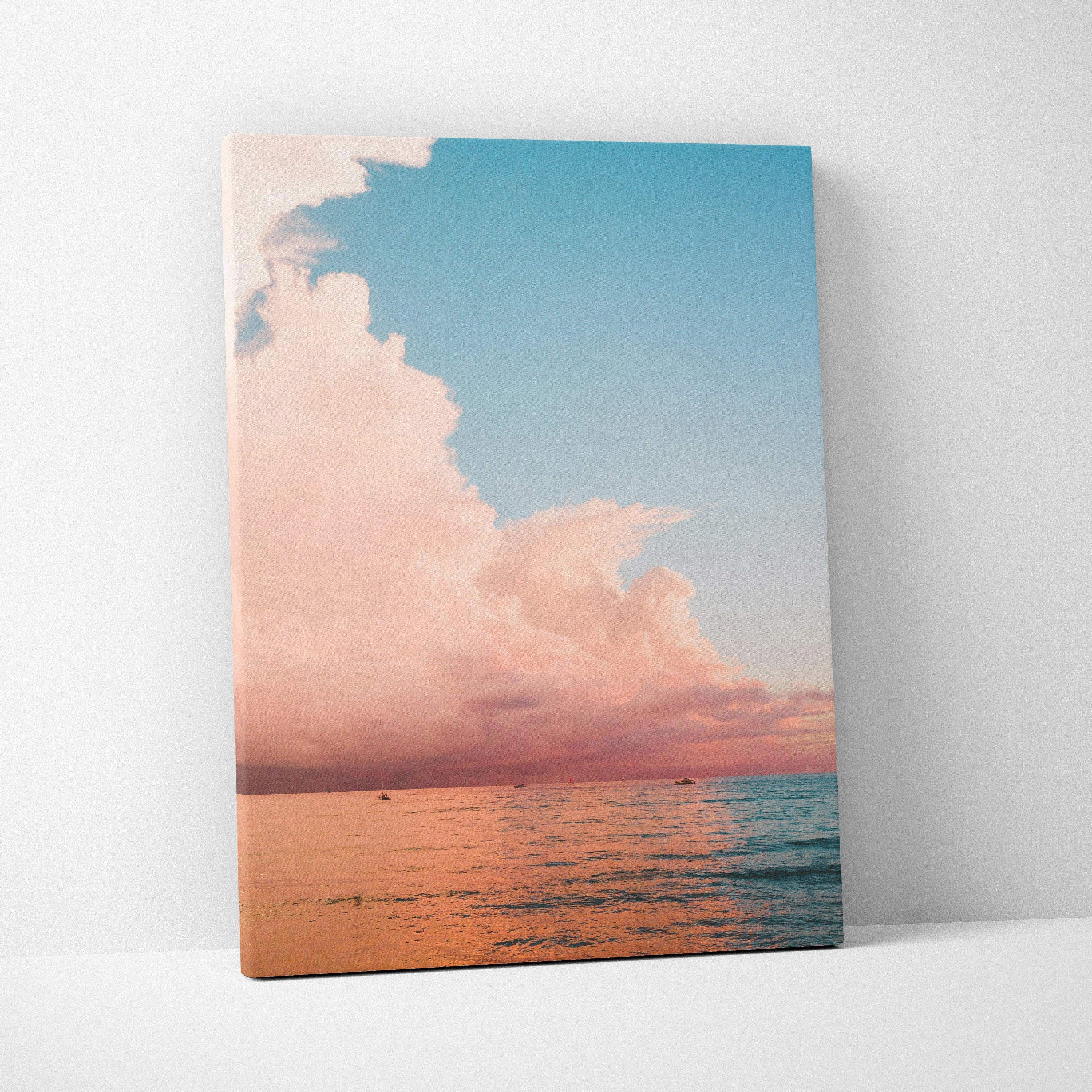 Ocean sunset over calm water with pink clouds on vertical canvas wall art.