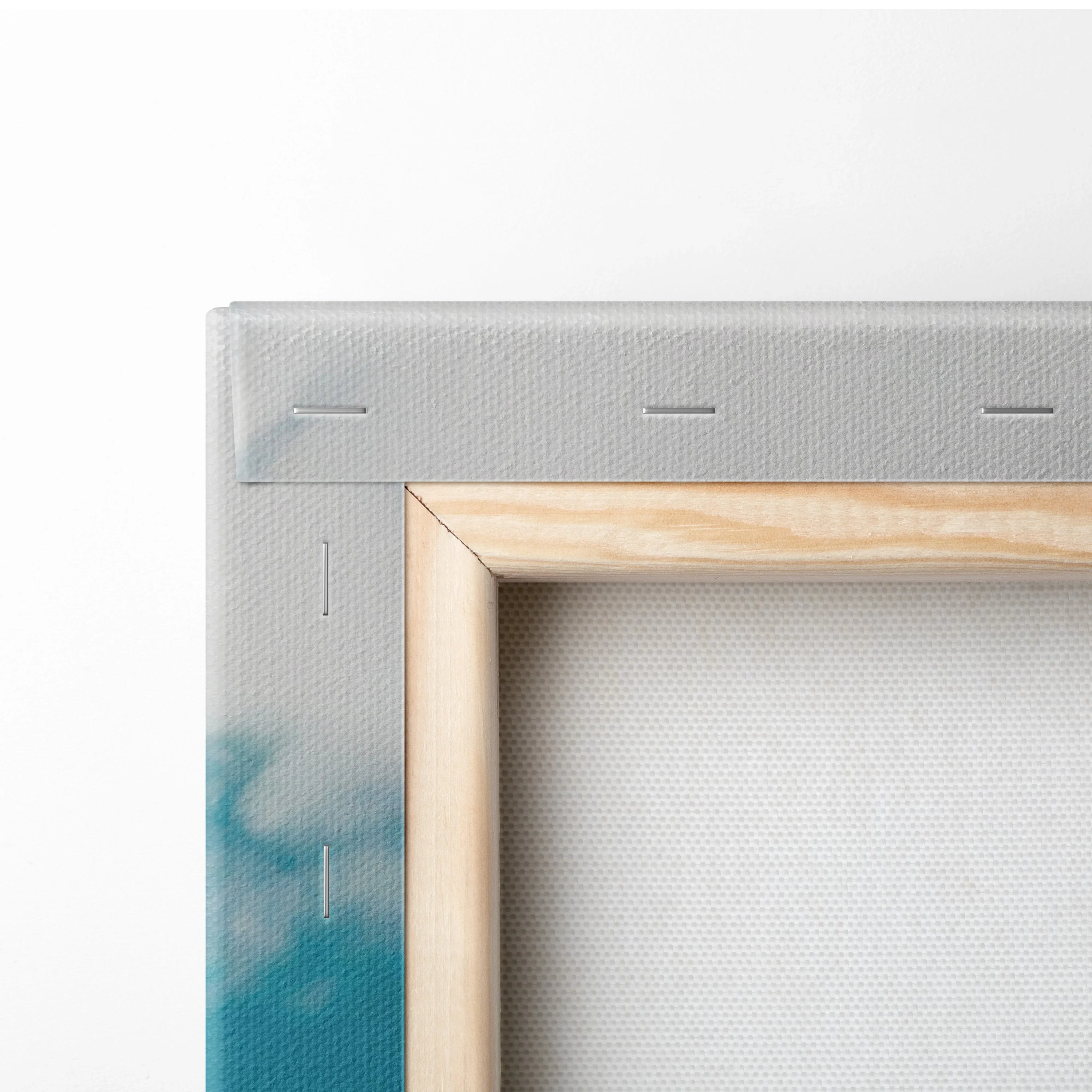 Close-up of wooden frame corner on canvas wall art with ocean blue and gray paint details.