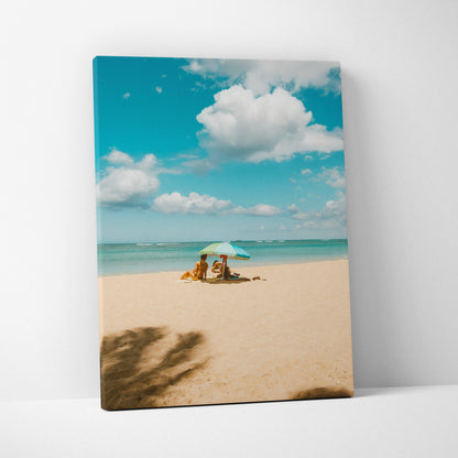 Canvas wall art featuring a tranquil beach scene with a blue sky, white clouds, and umbrella on sand.