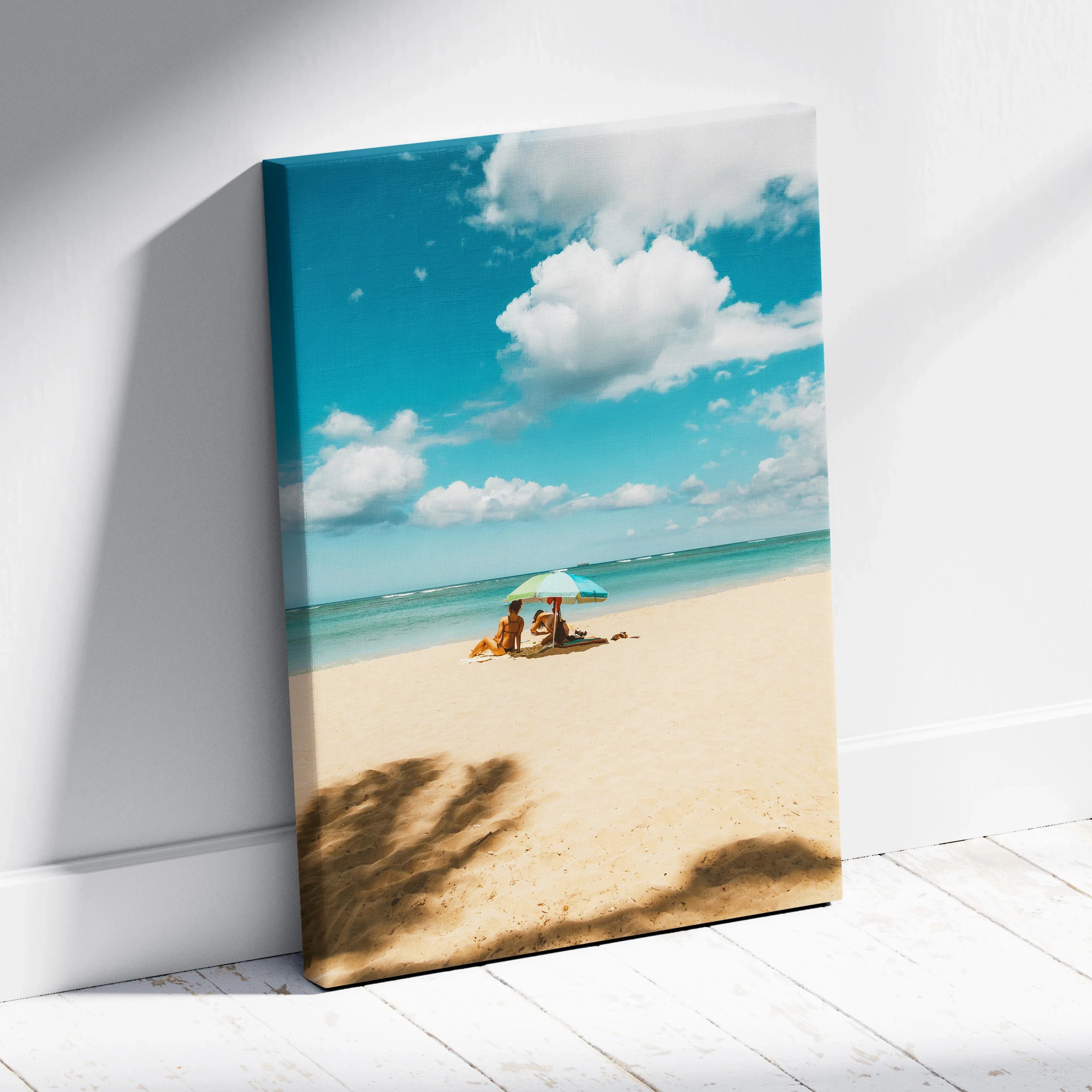 Canvas wall art featuring a serene ocean beach scene with a blue sky and white umbrella on sand.