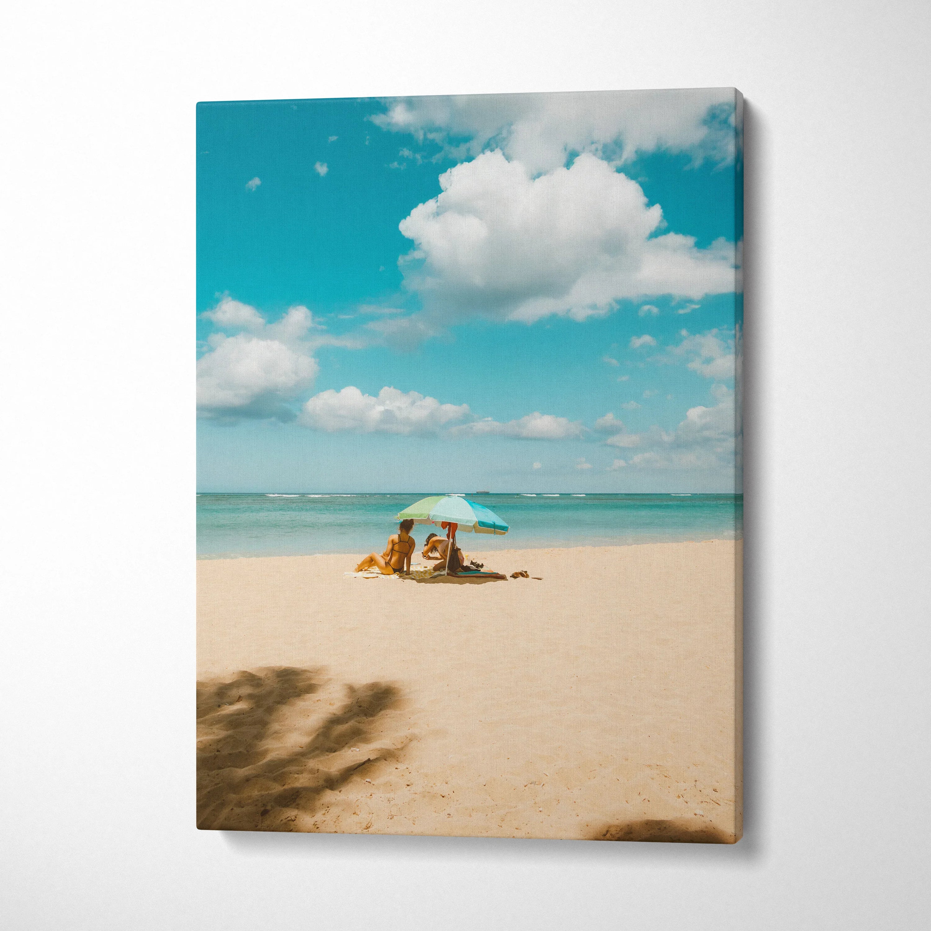 Vertical canvas wall art of a tranquil beach scene with turquoise sky and umbrella shade.