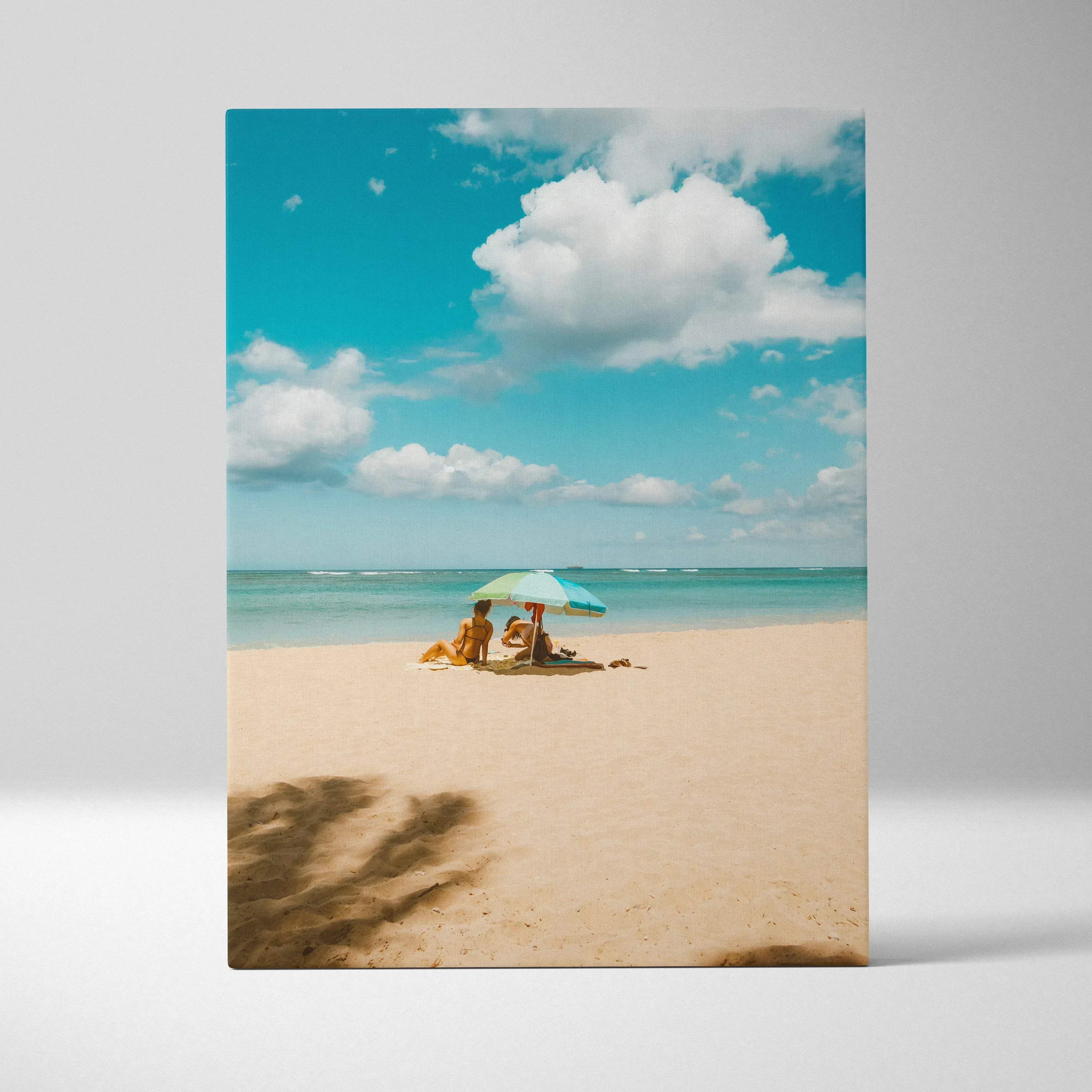 Calming ocean beach seascape canvas wall art showing two people under a striped umbrella on golden sand and turquoise water