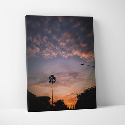 Vertical canvas wall art featuring a vibrant sunset with silhouetted palm trees and clouds.