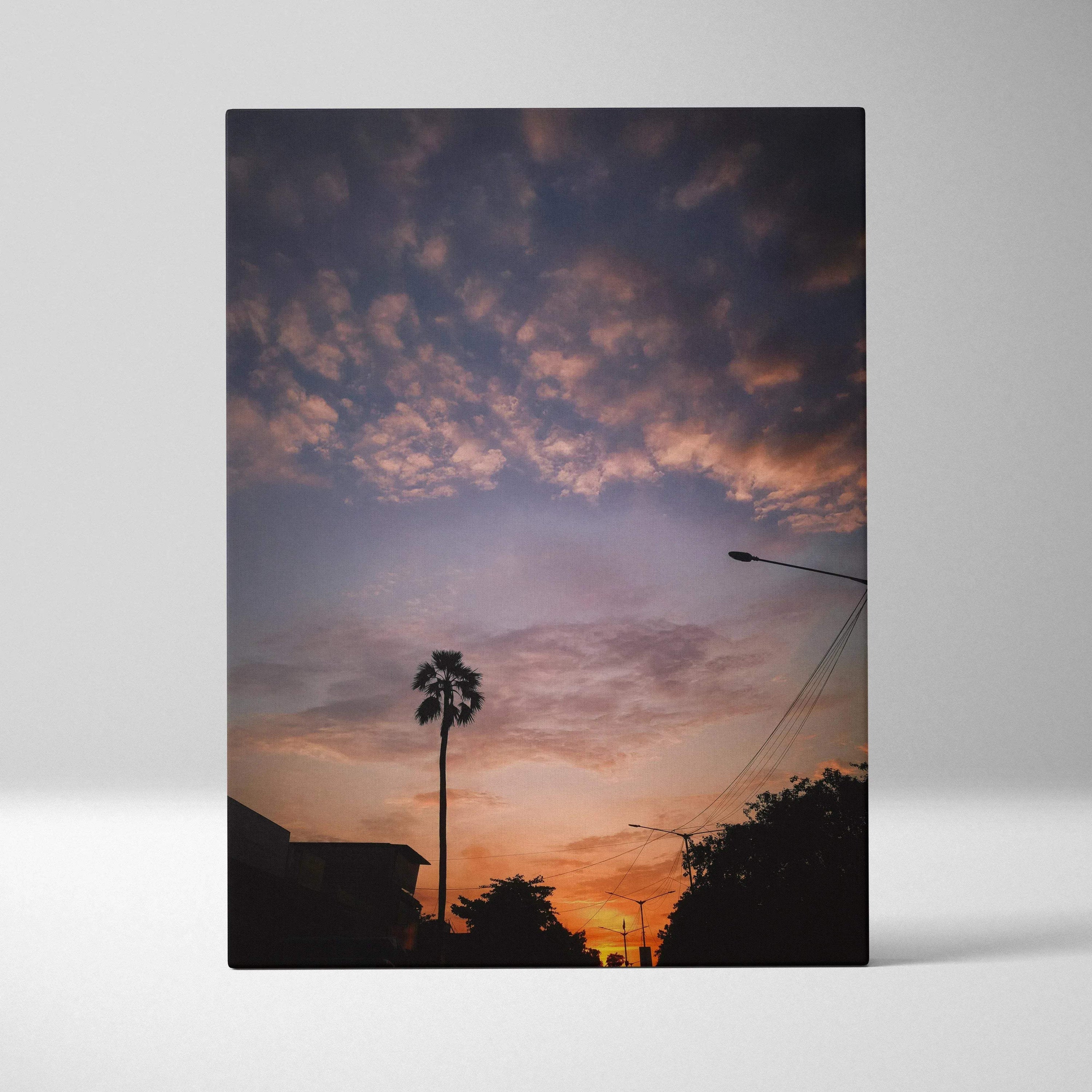 Vertical canvas wall art featuring a vibrant sunset with silhouetted palm tree and darkened landscape.