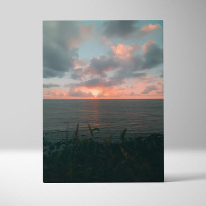Vertical canvas wall art featuring a serene beach ocean sunset with vibrant clouds and dark foreground plants.