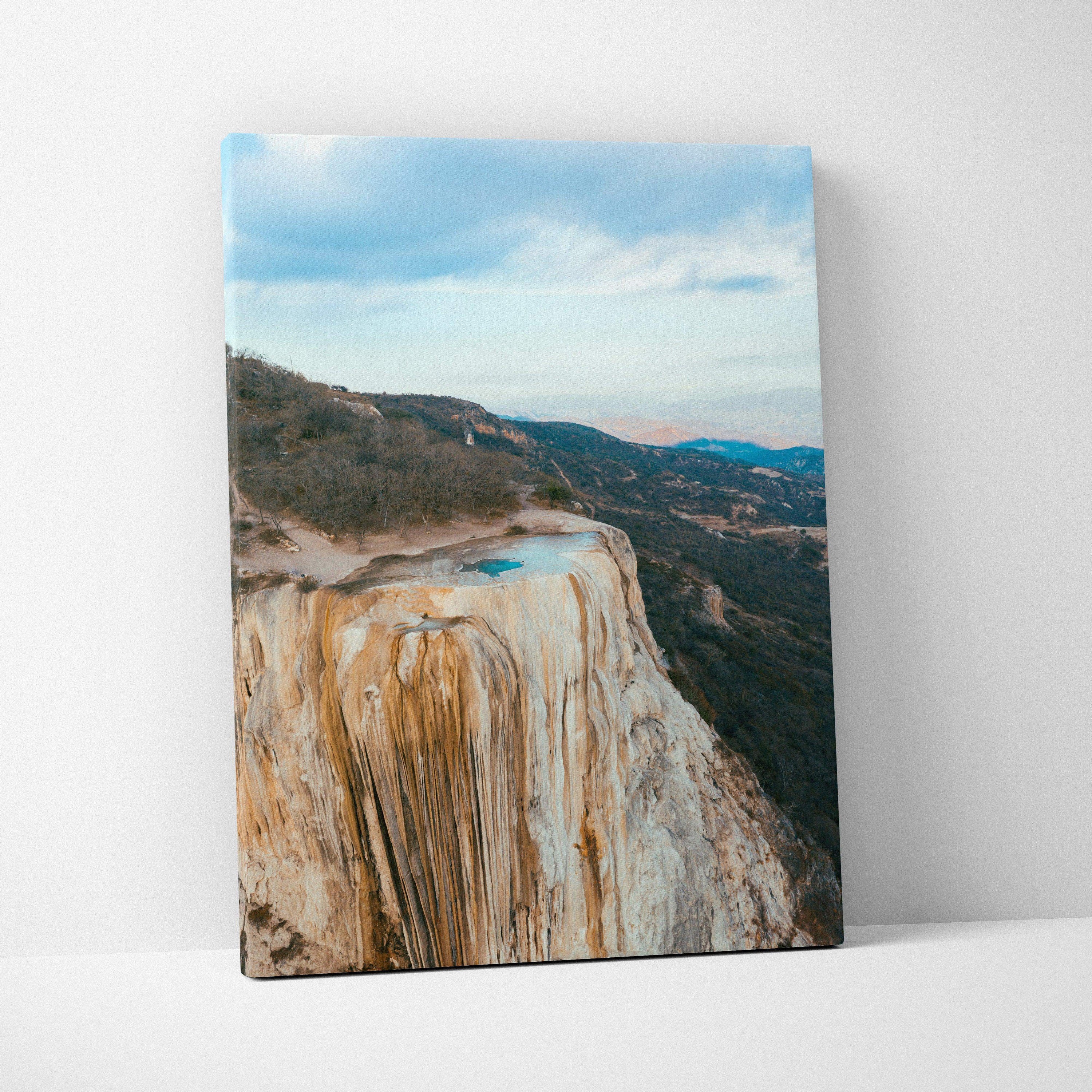 Mountain landscape canvas wall art featuring rocky cliffs and a serene blue sky backdrop.