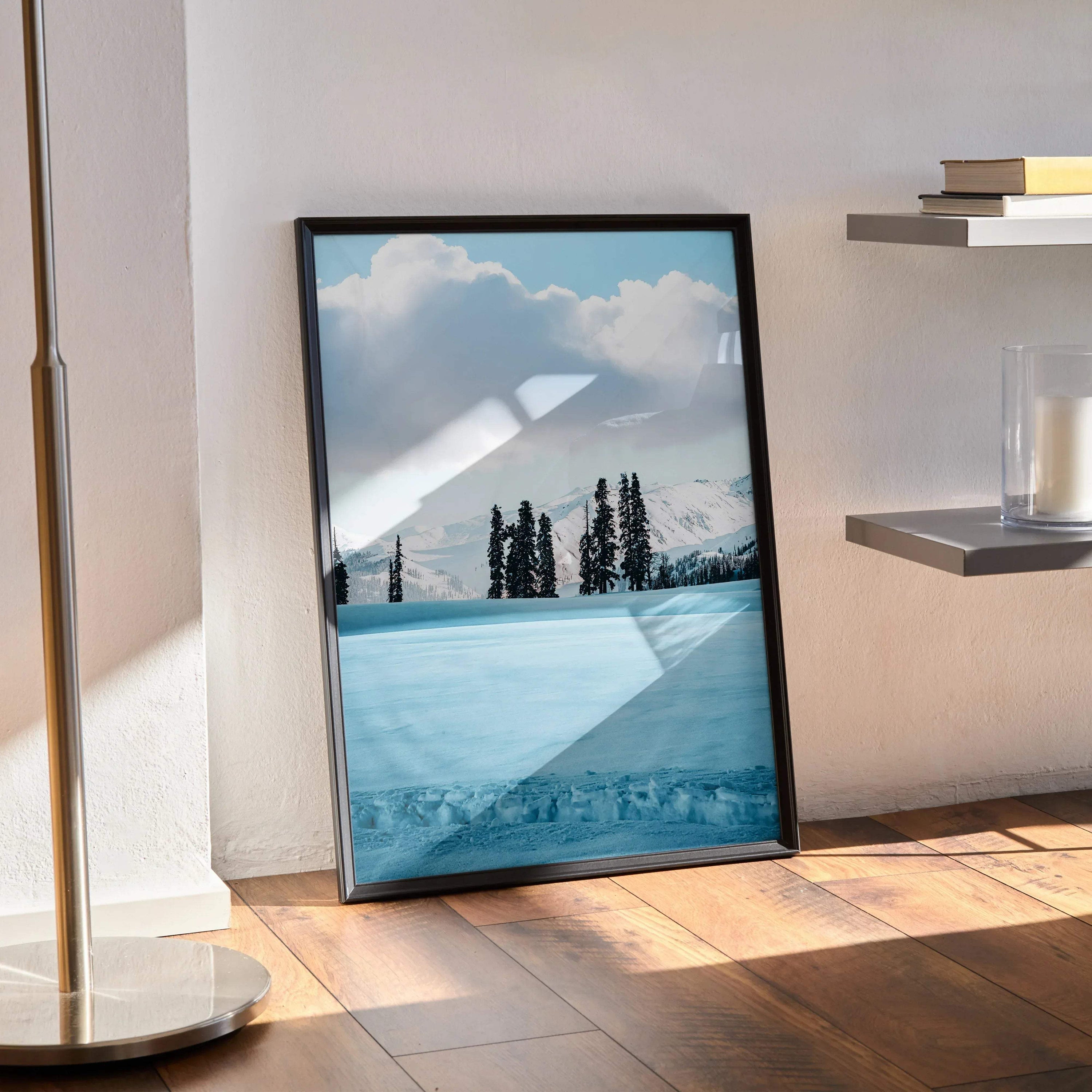 Snow-capped mountain poster wall art with pine trees and cloudy sky in black frame.