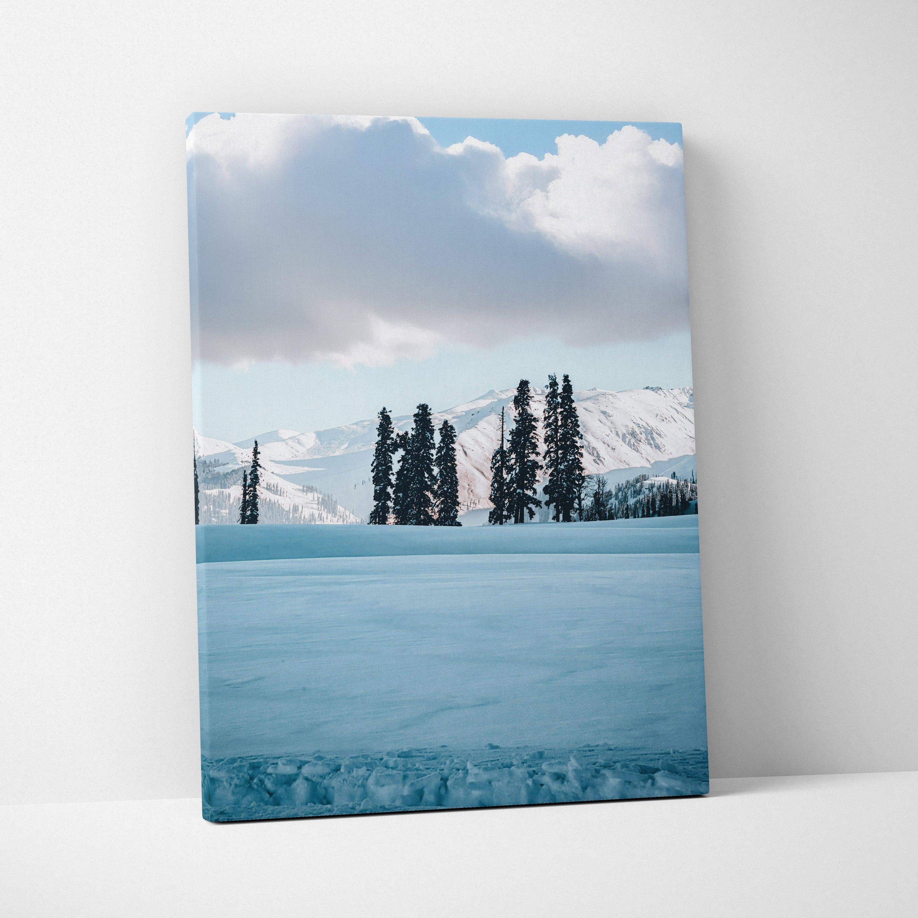 Snowy winter landscape canvas wall art with tall pine trees and snow-covered mountains.